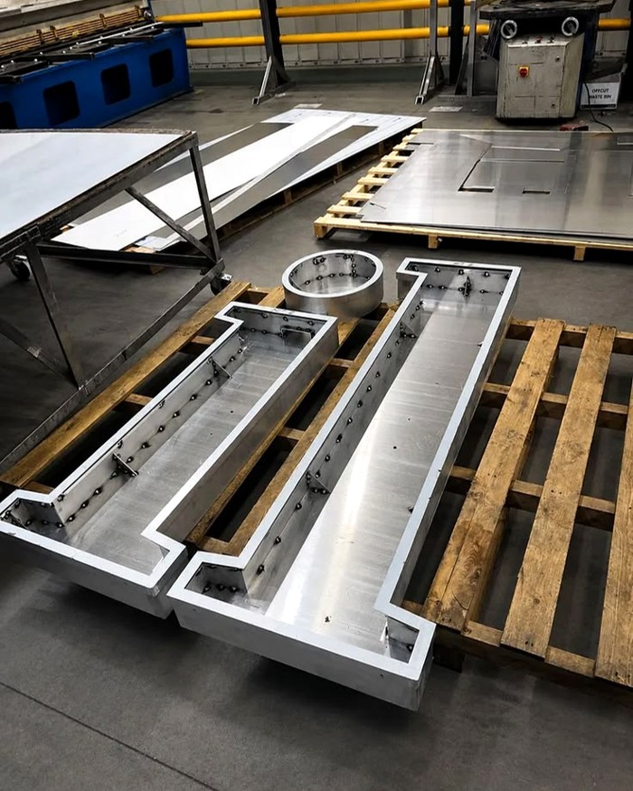 Metal sign enclosures laid out during fabrication